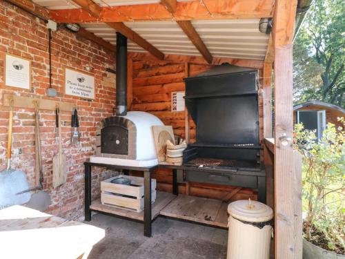 a outdoor kitchen with a stove in a brick wall at 1 Bed in Rocester oc-a33054 in Rocester