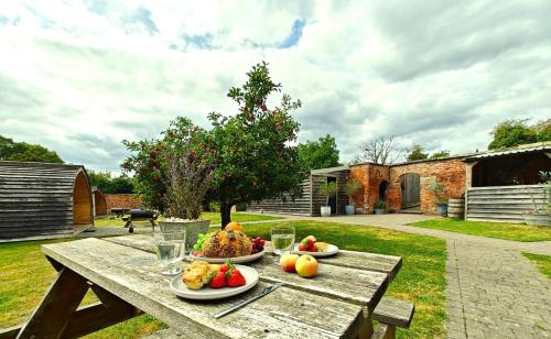 a wooden table with plates of fruit on it at 1 Bed in Rocester oc-o33055 in Rocester
