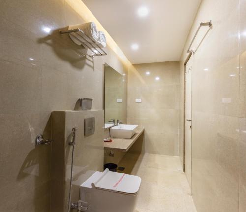 a bathroom with a toilet and a sink and a shower at Hotel Silver Oak 7 Minutes Walk to Mahalaxmi Temple in Kolhapur