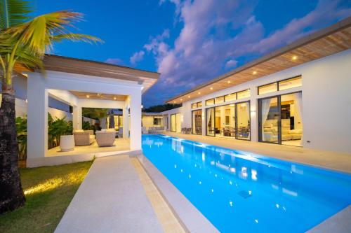 an exterior view of a house with a swimming pool at Ming Resort Phuket in Mai Khao Beach