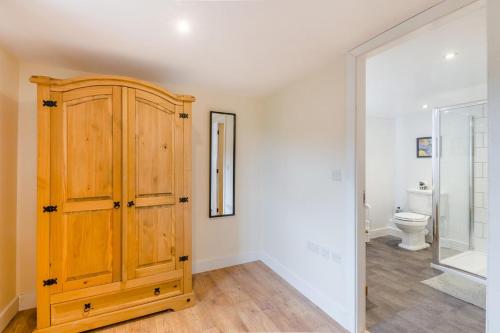 a bathroom with a wooden cabinet and a toilet at 3 Bed in Middleham oc-o32119 in Gammersgill