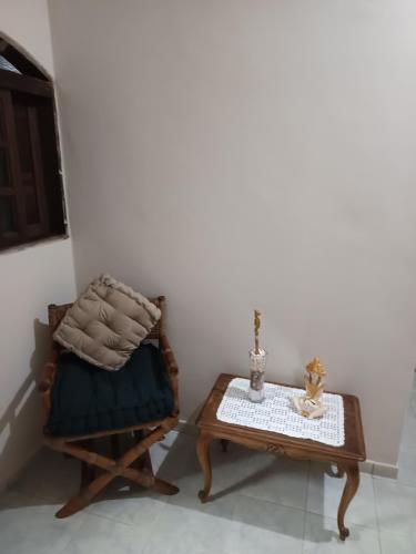 a living room with a chair and a table at Chácara braga in Itanhaém