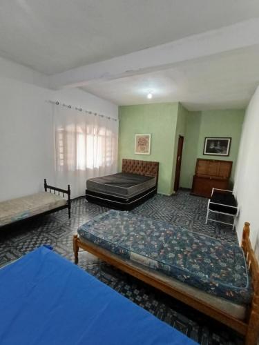 two beds in a room with green walls at Chácara braga in Itanhaém