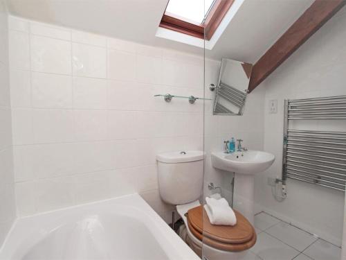 a white bathroom with a toilet and a sink at 3 Bed in Bamburgh oc-cn222 in Warenford