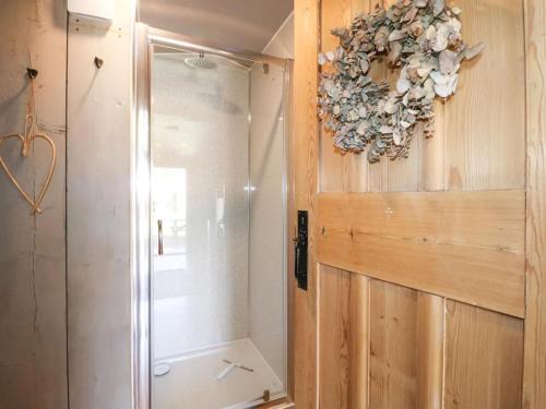 a bathroom with a shower and a door with a flower wreath at 1 Bed in Rocester oc-l33056 in Rocester