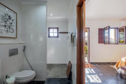 a white bathroom with a toilet and a shower at Monte da Pechincha - Casa de Hóspedes & Spa in Estremoz