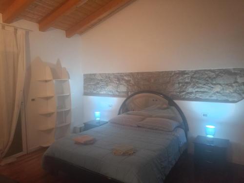 a bedroom with a bed and two lights on two tables at Corte Don Bosco 4 in Monfalcone