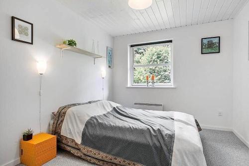 a white bedroom with a bed and a window at SJ323-Aabenraa-Kloften-14 in Loddenhøj