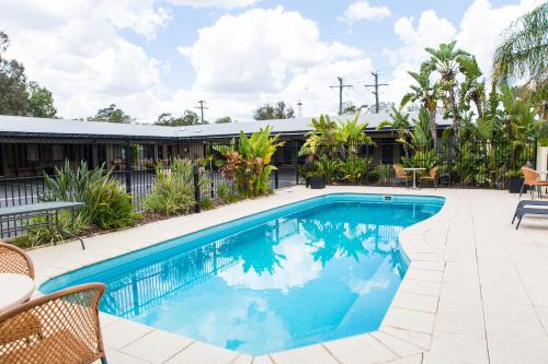 Una piscina con agua azul en un patio. en Best Western Bungil Creek Motel, en Roma