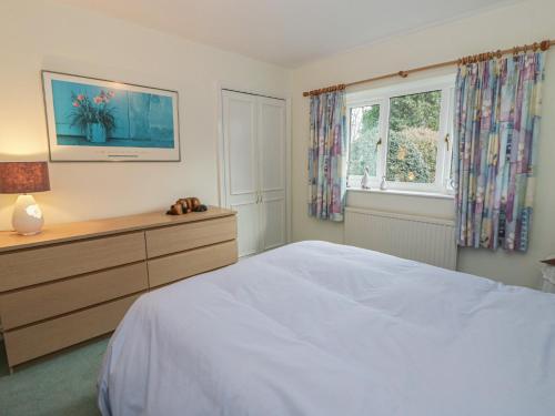 a bedroom with a bed and a dresser and a window at Summerhill in Hereford