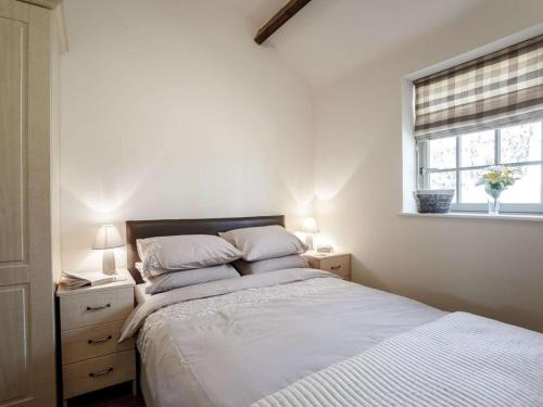 a bedroom with a bed with two lamps and a window at 1 Bed in Hexham oc-82473 in Hexham