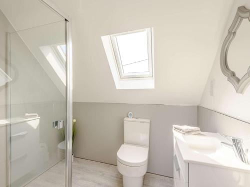 a white bathroom with a toilet and a sink at 1 Bed in Weymouth oc-82098 in Osmington