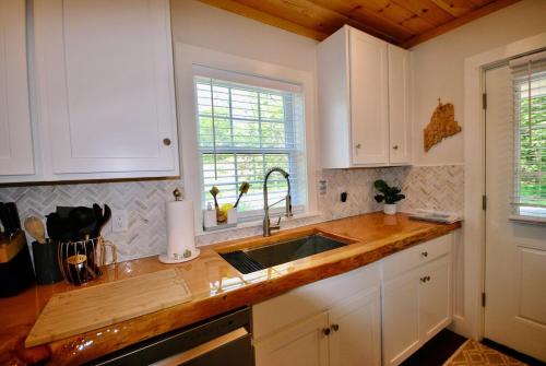 a kitchen with white cabinets and a sink at 3 Bedroom Happy Cottage 15 in Edgecomb