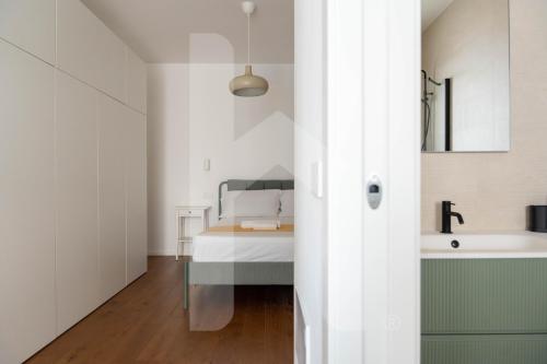 a bathroom with a bed and a sink in a room at Homiday - WaterFront Roseto in Roseto degli Abruzzi
