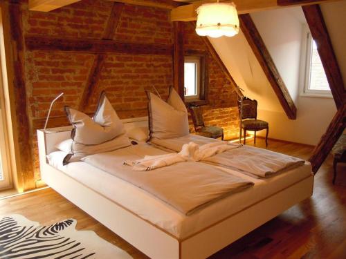 a large bed in a room with a brick wall at Design trifft Denkmal in Wangen im Allgäu