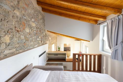 a bedroom with a bed and a stone wall at Residence Palmento in Franciacorta in Corte Franca