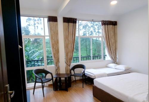 a bedroom with two beds and a table and chairs at Hill Cool Hotel & Restaurant in Hatton