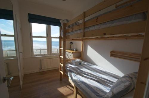 a bedroom with two bunk beds and two windows at Oceanview in Woolacombe