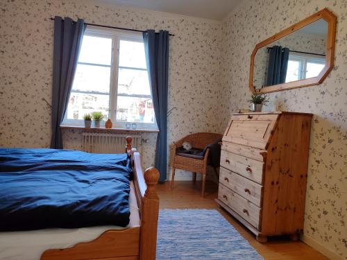 a bedroom with a bed and a dresser and a window at Mistel in Filipstad