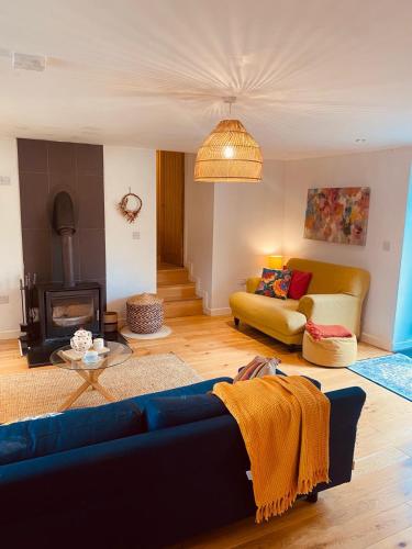 a living room with a blue couch and a fireplace at Crymlyn barn in Llanwrda