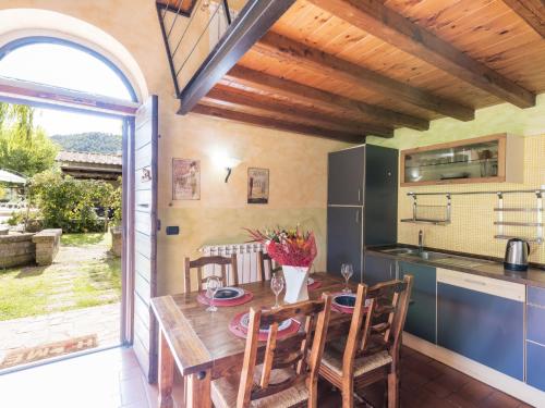 a kitchen with a wooden table and chairs and an open window at Apartment Casa Alessandro n-5 by Interhome in Montefiascone