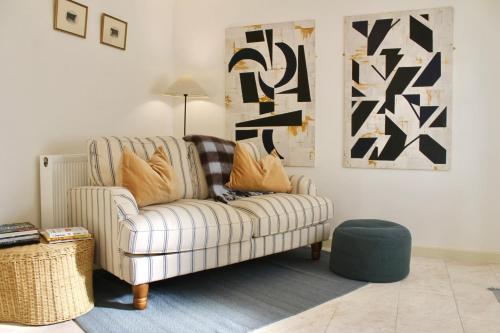 a living room with a couch and a ottoman at Cosy Cottage in Rural Lympsham in Lympsham