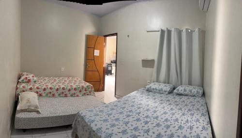 a bedroom with two beds and a door to a hallway at Perfeita casa estilo apartamento in São Luís