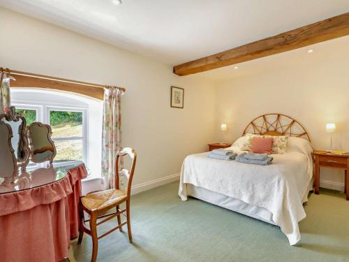 a bedroom with a bed and a desk and a window at 2 Bed in Dulverton oc-threb in East Anstey