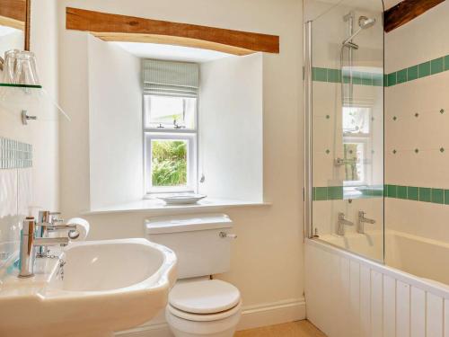 a bathroom with a toilet and a sink and a shower at 2 Bed in Dulverton oc-threb in East Anstey
