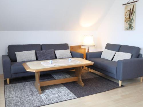 a living room with two blue couches and a coffee table at Apartment Schonerweg by Interhome in Norddeich