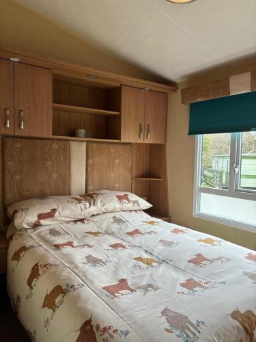 a bedroom with a bed with a blanket on it at The Grosvenor 45 in Ardentinny