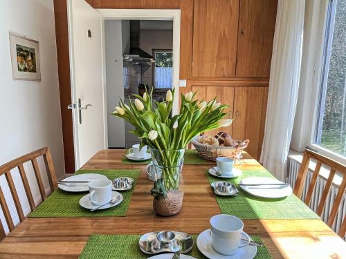 a dining room table with a vase of flowers on it at Holiday Home Sonnenbühl by Interhome in Dittishausen