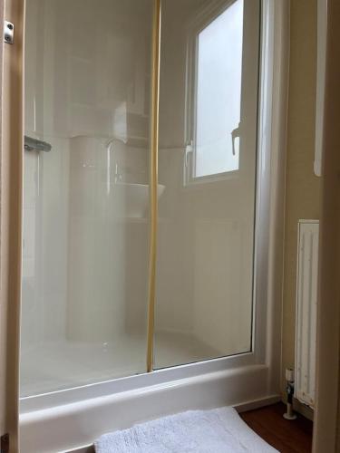 a glass shower in a bathroom with a window at The Grosvenor 45 in Ardentinny