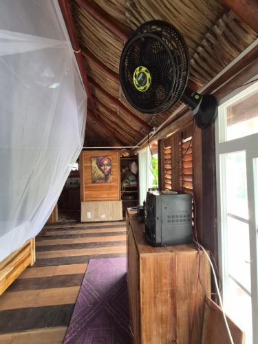 a room with a fan on a wooden ceiling at Cabaña LA IGUANA in Capurganá