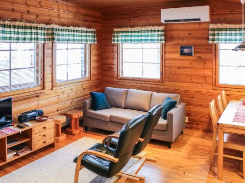 a living room with a couch and a table at Holiday Home Ruskatupa by Interhome in Ruka