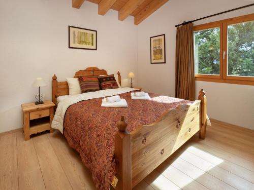 a bedroom with a large bed and a window at Chalet Banksia by Interhome in Ovronnaz