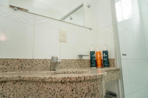 a bathroom with a sink and a mirror at Hotel Canaan in Sete Lagoas