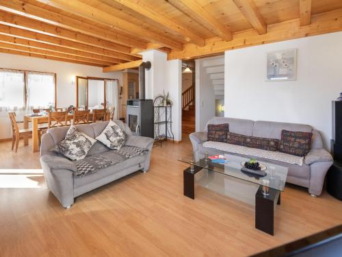 a living room with two couches and a table at Chalet Orchidée by Interhome in Ovronnaz