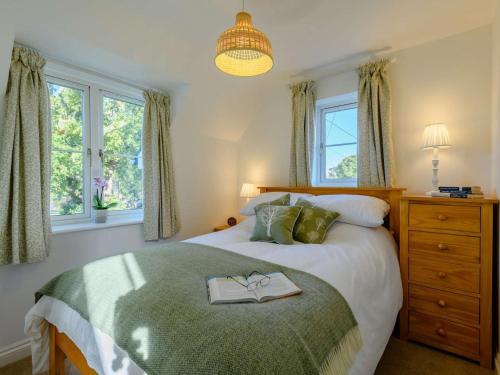 a bedroom with a bed with a book on it at 3 Bed in Lymington oc-90002 in Sway