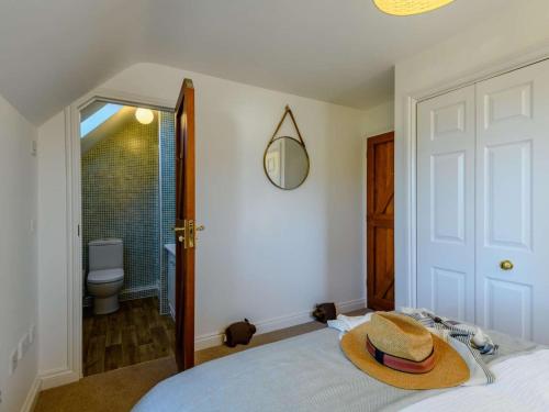 a room with a bed with a hat on it at 3 Bed in Lymington oc-90002 in Sway