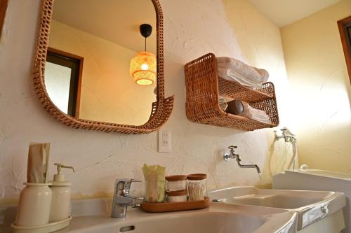 a bathroom with a sink and two mirrors at 南国リゾート Bari Okinawa 連泊宿泊限定価格 in Itoman