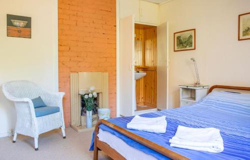a bedroom with a blue bed and a chair at The Blue Lobster in Drynoch