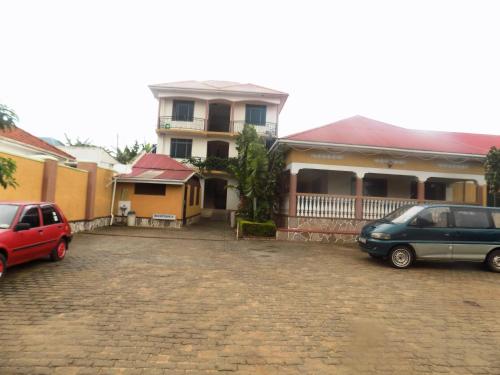 a car parked in a parking lot in front of a house at Rhino Motel Mbarara in Mbarara