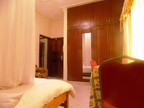 a bedroom with a bed and wooden cabinets at Rhino Motel Mbarara in Mbarara