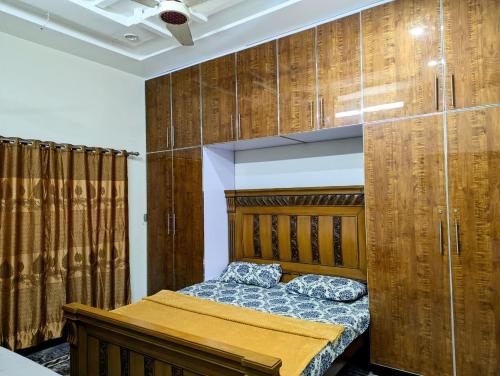 a bedroom with a bed and wooden cabinets at House No 6, Valley Homes in Pothi