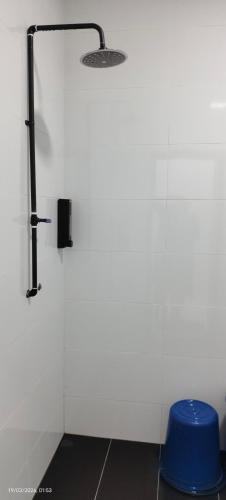 a bathroom with a white wall and a blue stool at Homestay Rumah 311 in Sungai Petani