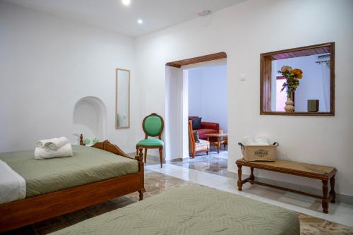 a bedroom with a bed and a chair and a table at Old Town Nest in Rhodes Town