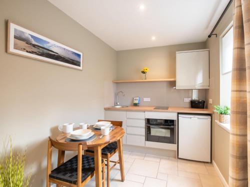 a kitchen with a wooden table and a small dining room at Apartment Wayside Loft by Interhome in Drumnadrochit