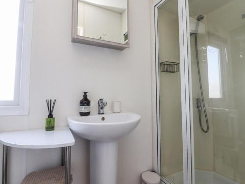 a white bathroom with a sink and a shower at Cornholme Lodge in Accrington