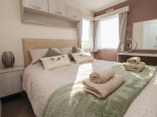 a bedroom with a bed with towels on it at Cornholme Lodge in Accrington